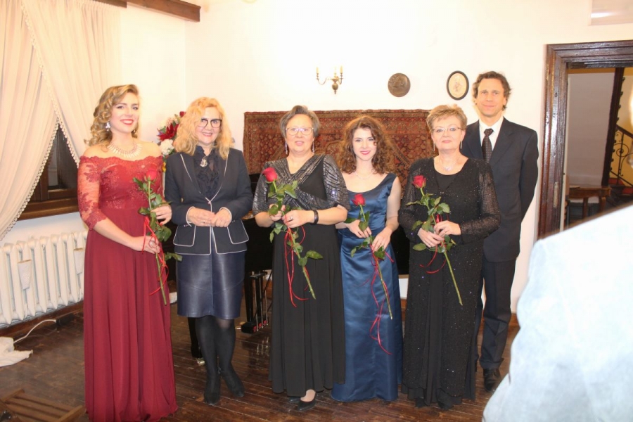 Pięć kobiet z czerwonymi różami w rękach. Po prawej stronie stoi za nimi mężczyzna.