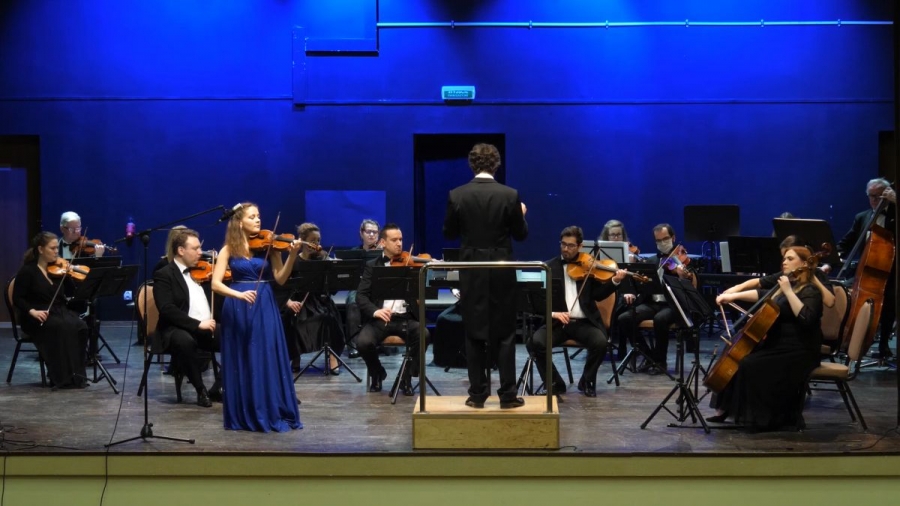 Orkiestra wraz ze skrzypaczką w sukni w kolorze chabrowym.