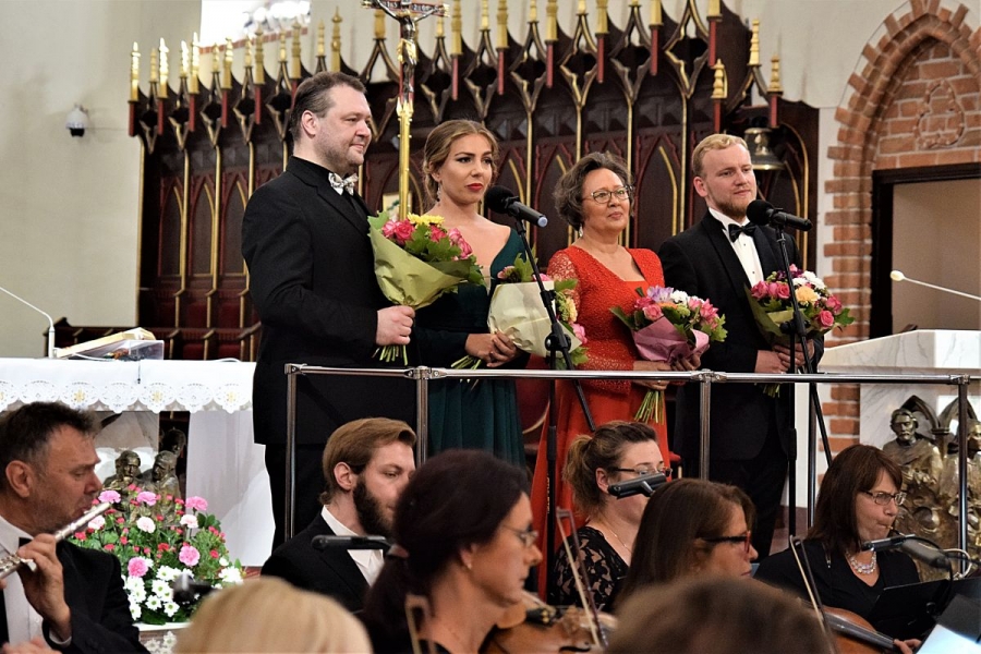 Czterech solistów z bukietami kwiatów.